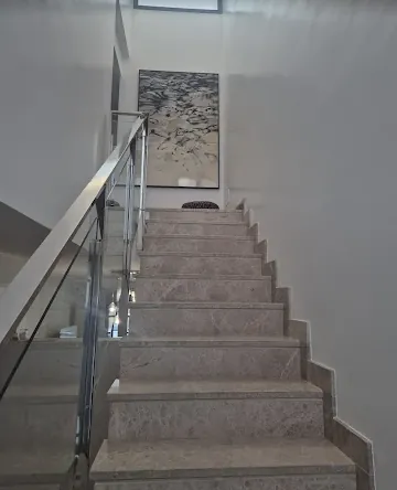 Escalera de mármol con barandilla de vidrio, reforma realizada por Erkema Multiservicios